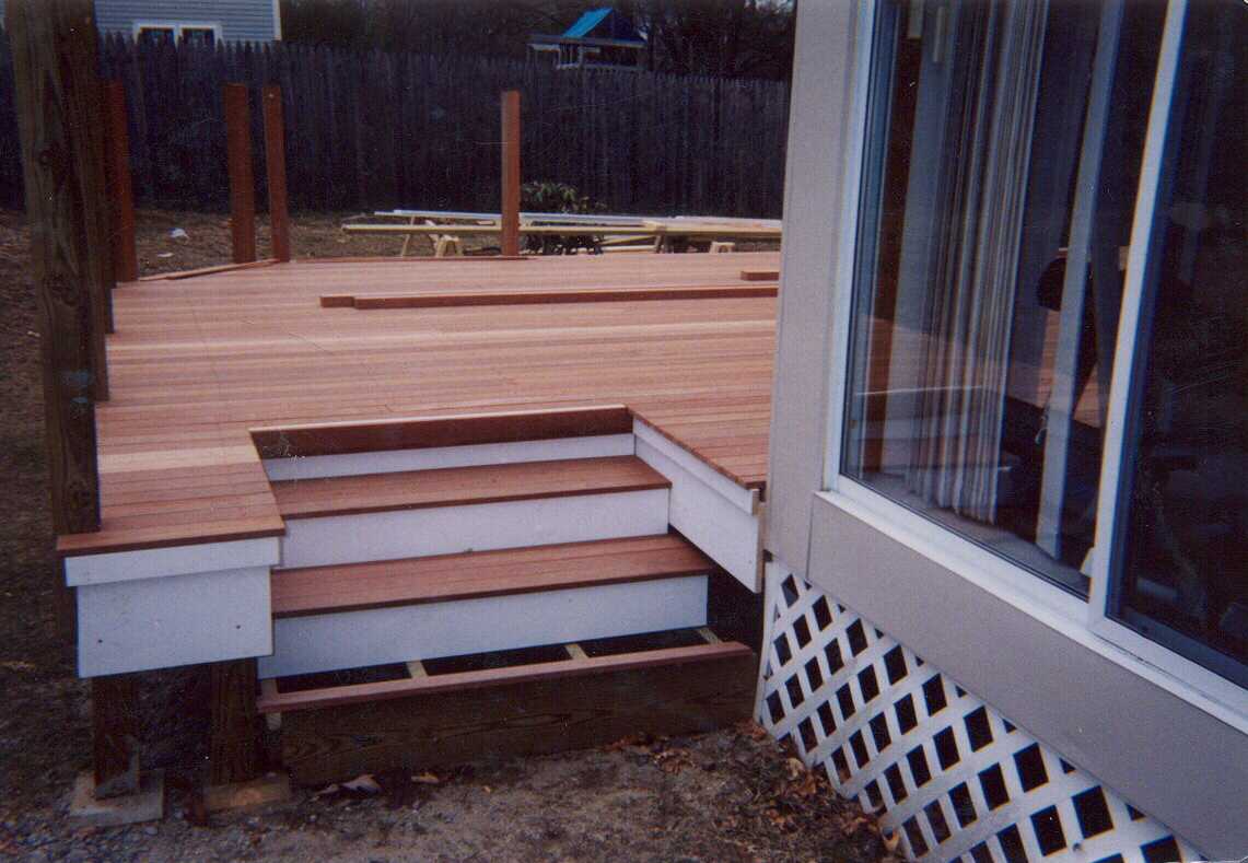 Mahogany deck, screen, benchwork and planters.  Stairs to grade.  Step work in rear.